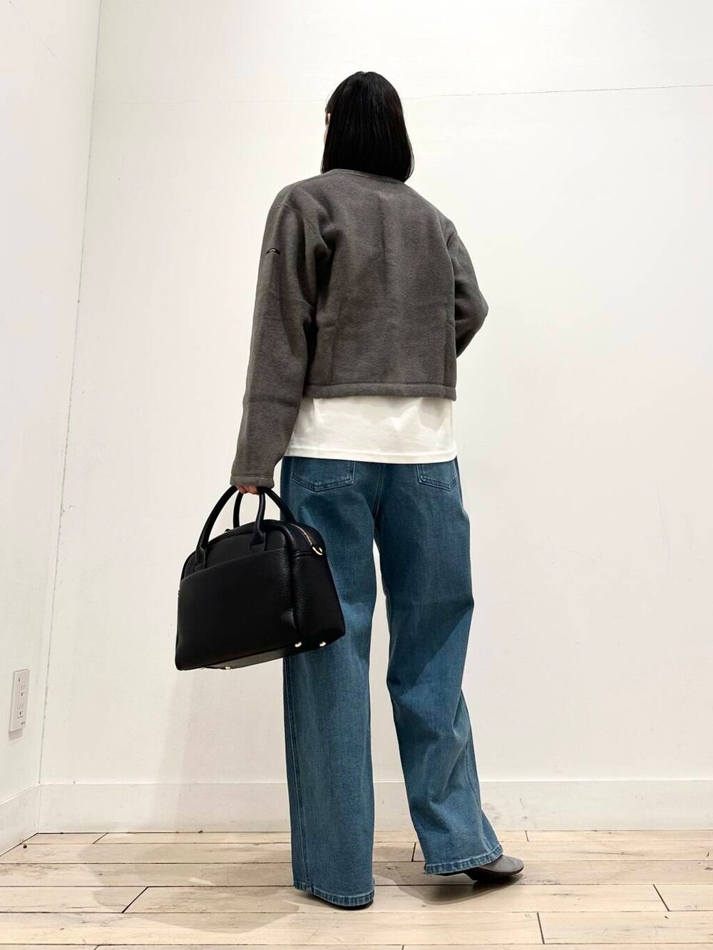 ブラック系のボストンバッグ、グレー系のバレエシューズ、グレー系のカーディガン/ボレロを着用したレディースの秋コーディネートの3枚目の写真