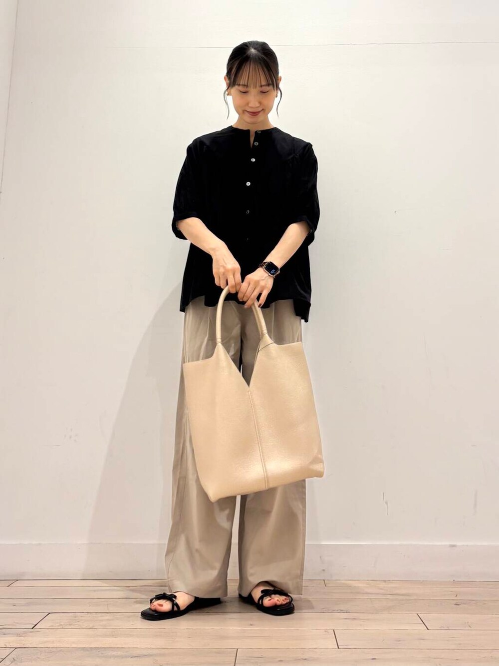 ベージュ系のその他パンツ、ゴールド系のトートバッグ、ブラック系のシャツ/ブラウスを着用したレディースの夏コーディネートの2枚目の写真