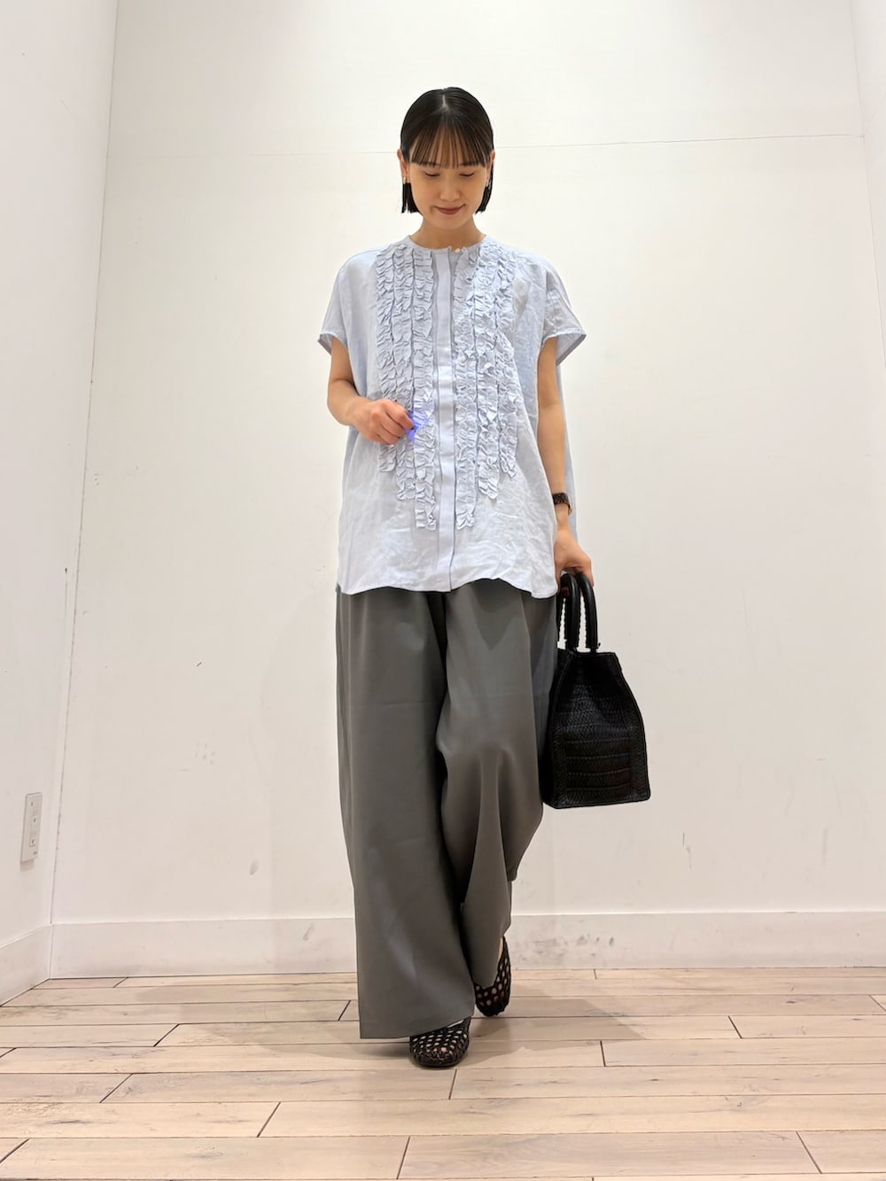 ブルー系のシャツ/ブラウス、グレー系のその他パンツ、ブラック系のハンドバッグを着用したレディースの春コーディネートの2枚目の写真