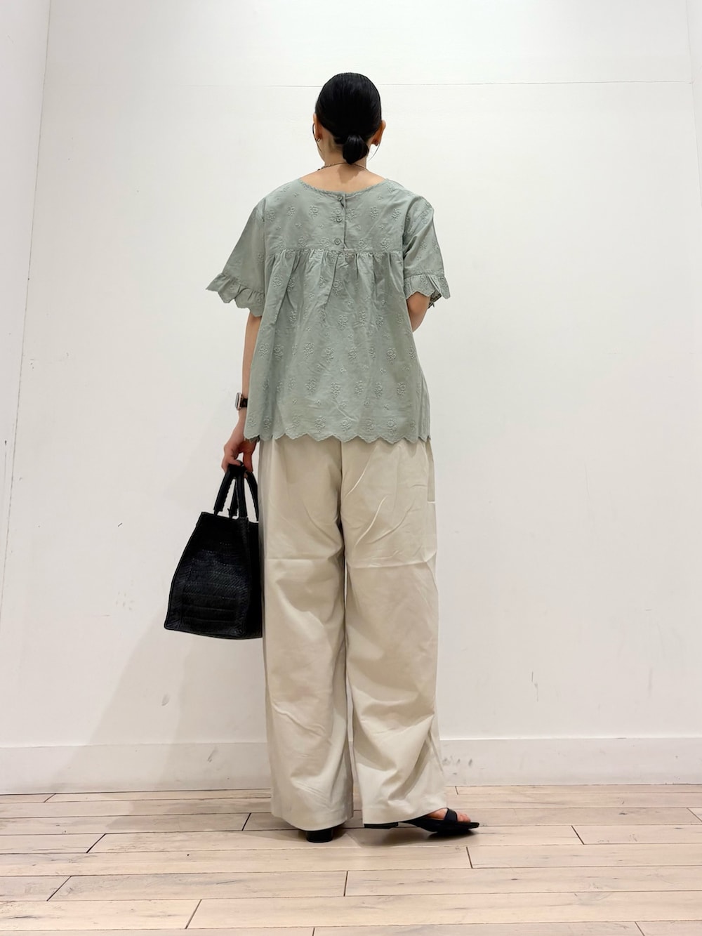 グリーン系のシャツ/ブラウス、ホワイト系のその他パンツ、ブラック系のハンドバッグを着用したレディースの夏コーディネートの4枚目の写真