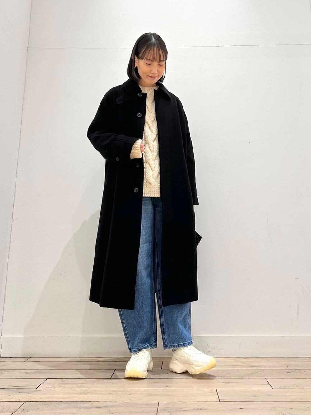 ブラック系のショルダーバッグ、ホワイト系のスニーカー、ブラック系のその他アウターを着用したレディースの冬コーディネートの5枚目の写真