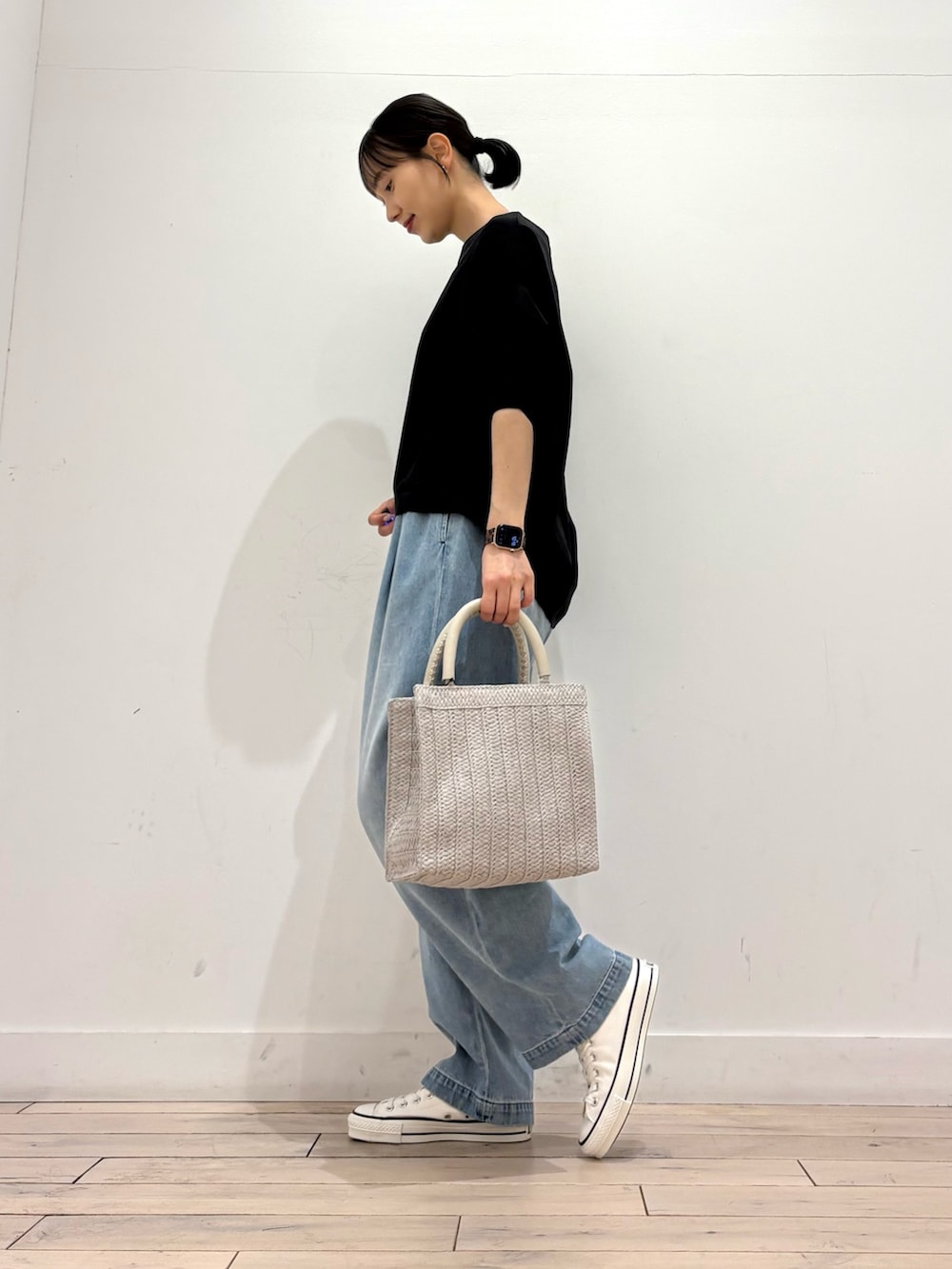 ブラック系のTシャツ/カットソー、グレー系のハンドバッグ、ブルー系のデニムパンツを着用したレディースの春コーディネートの3枚目の写真