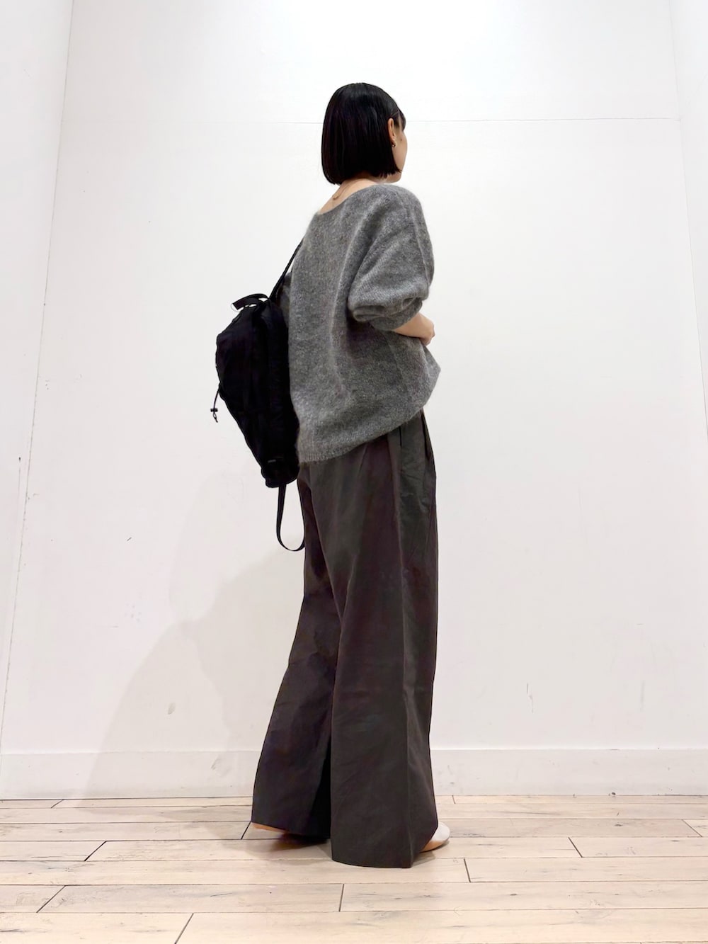 グレー系のニット/セーター、グレー系のその他パンツ、ホワイト系のスニーカーを着用したレディースの秋コーディネートの4枚目の写真