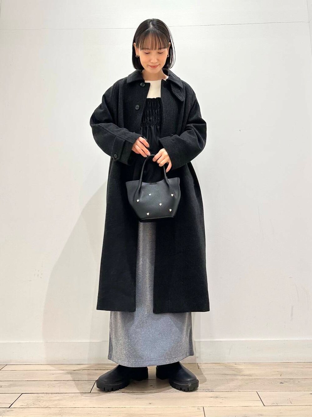 グレー系のその他アウター、ブラック系のブーツ、グレー系のスカートを着用したレディースの冬コーディネートの5枚目の写真