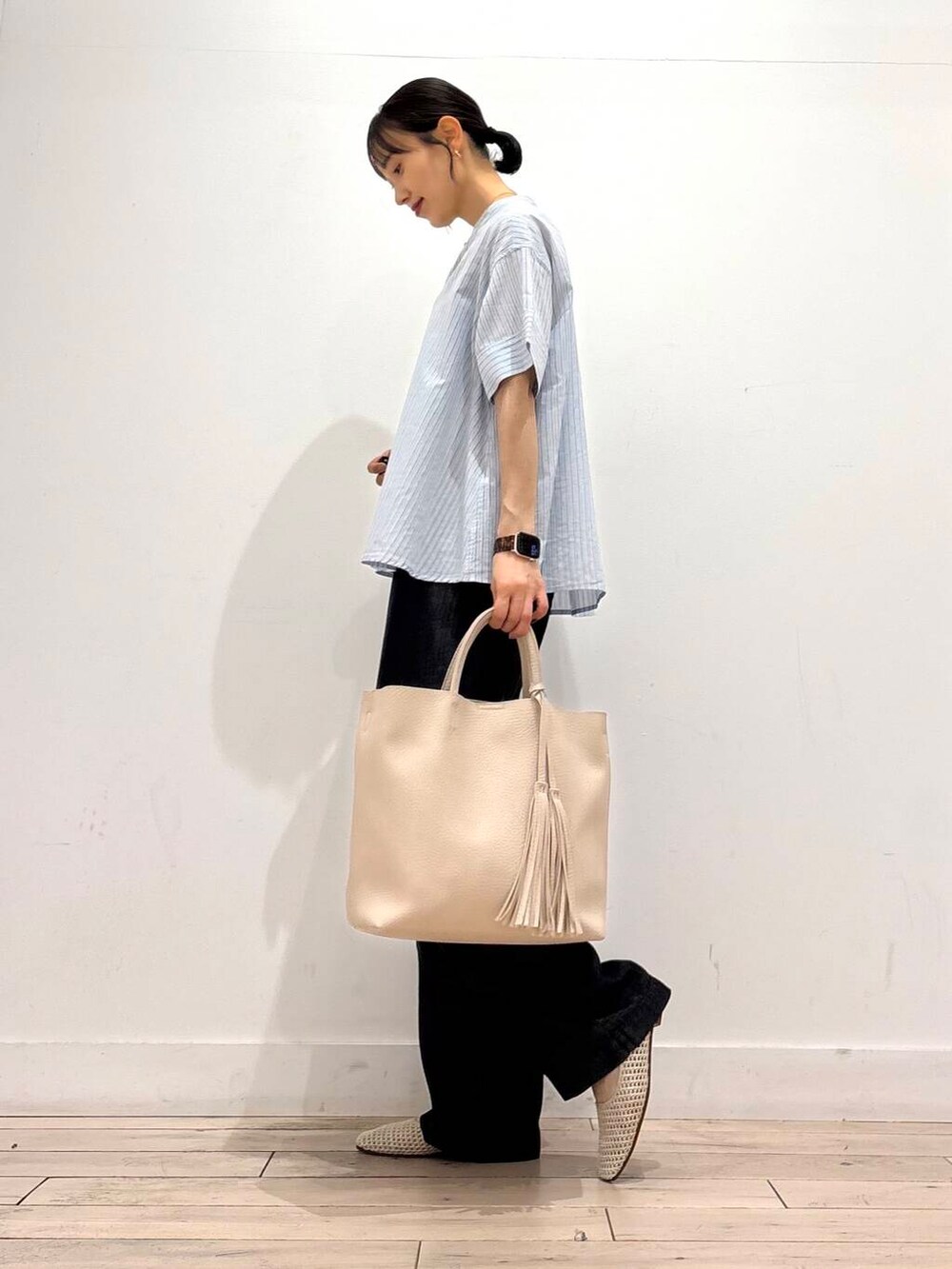 ホワイト系のトートバッグ、ホワイト系のバレエシューズ、ブラック系のデニムパンツを着用したレディースの夏コーディネートの3枚目の写真