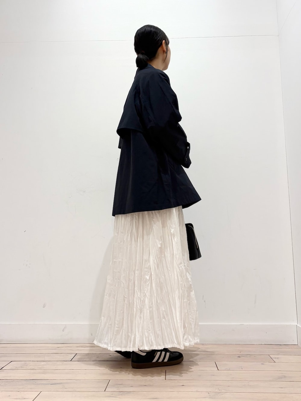 ブラック系のTシャツ/カットソー、ブラック系のスニーカー、グレー系のスカートを着用したレディースの春コーディネートの3枚目の写真