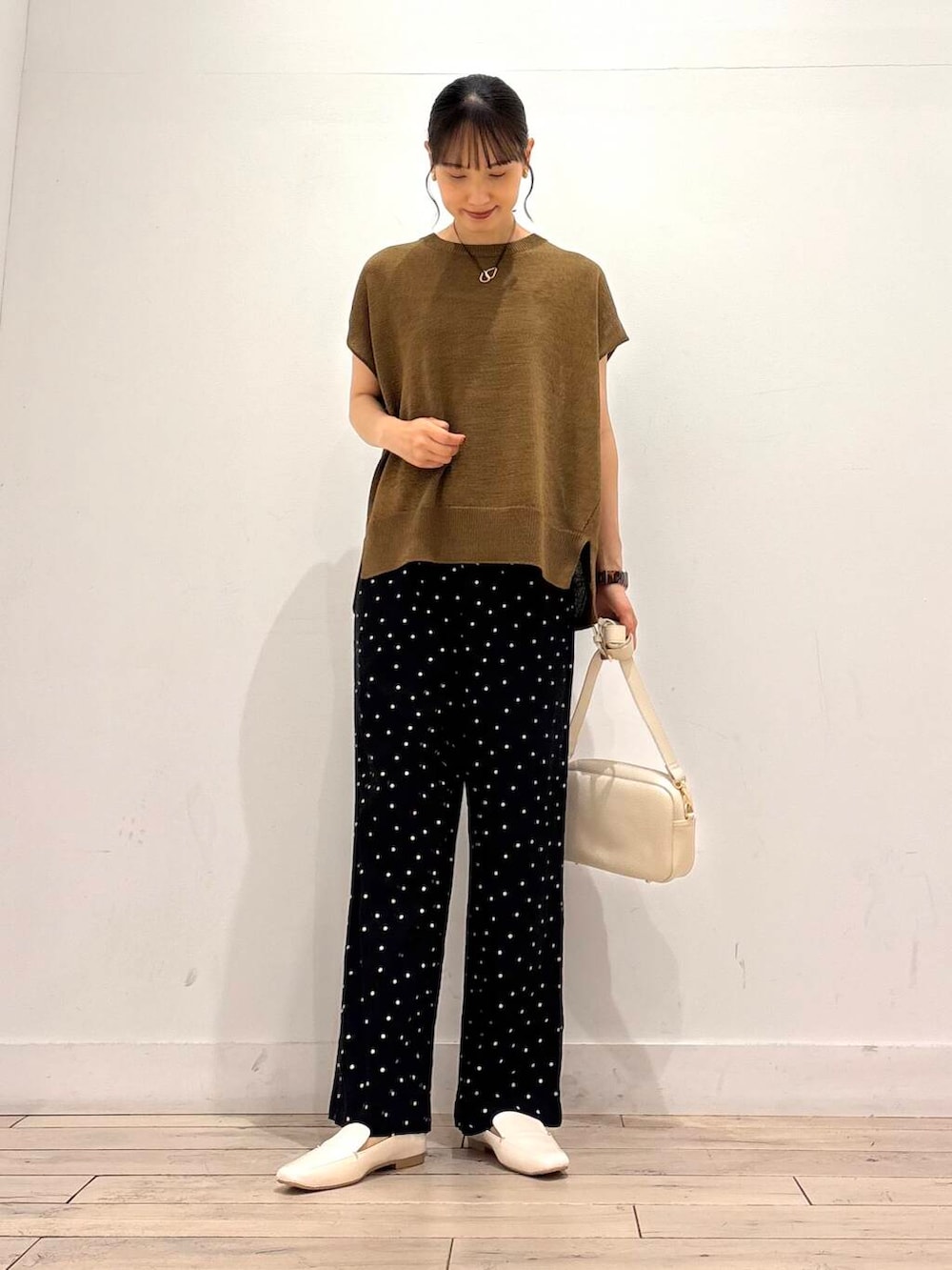 ホワイト系のローファー、ホワイト系のショルダーバッグ、ブラック系のその他パンツを着用したレディースの夏コーディネートの2枚目の写真