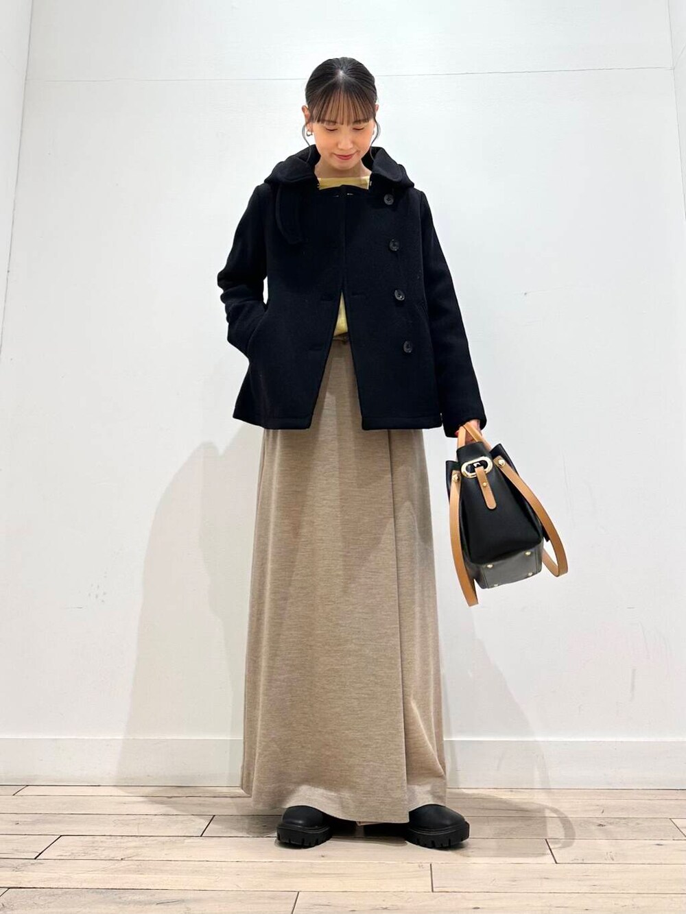 ブラック系のトートバッグ、ブラック系のその他アウター、ブラック系のブーツを着用したレディースの冬コーディネートの4枚目の写真