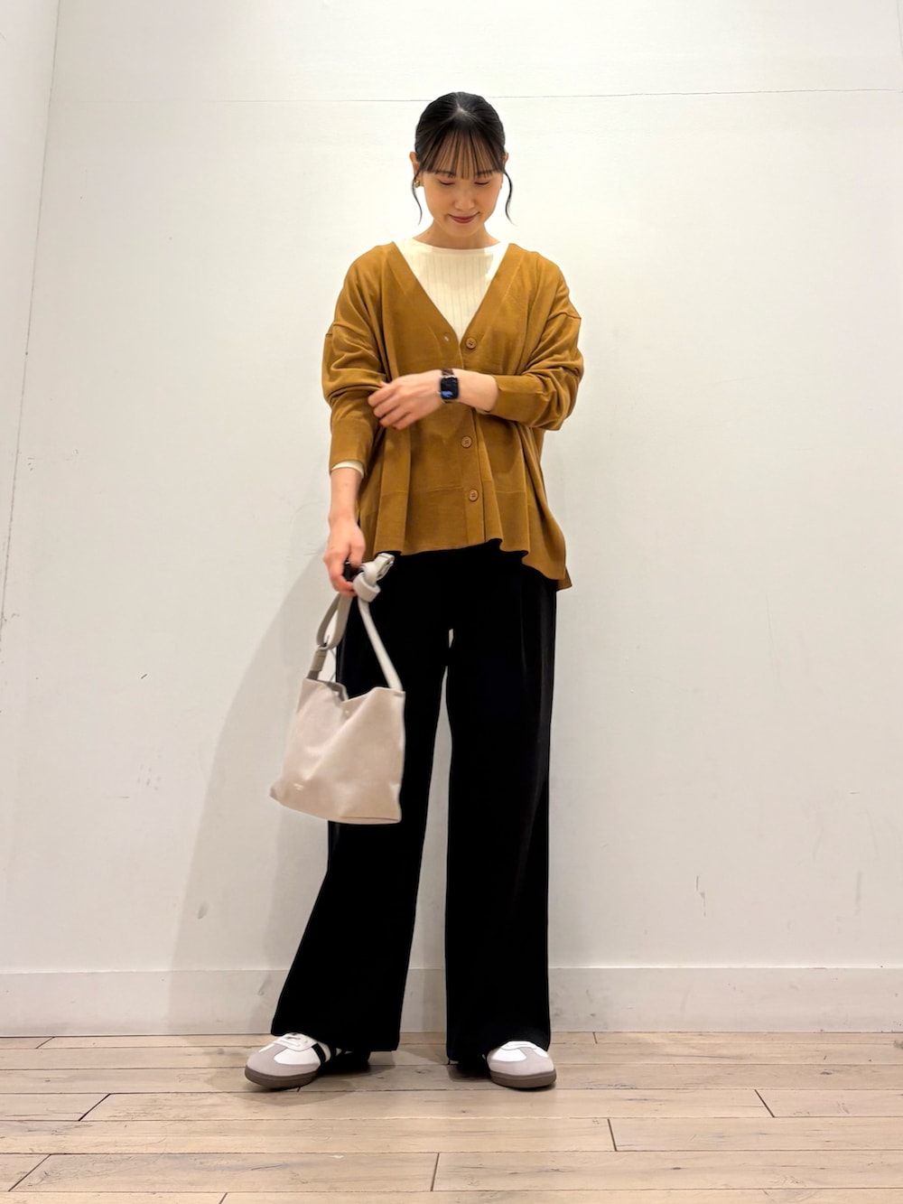 ゴールド系のカーディガン/ボレロ、ホワイト系のTシャツ/カットソー、ホワイト系のスニーカーを着用したレディースの秋コーディネートの2枚目の写真