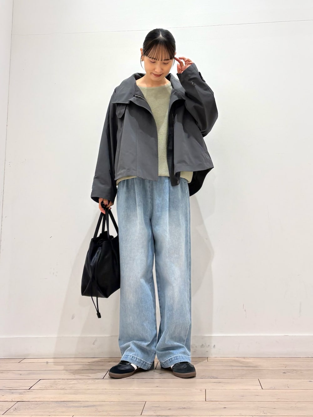 グリーン系のニット/セーター、グレー系のその他アウター、ブラック系のショルダーバッグを着用したレディースの春コーディネートの2枚目の写真