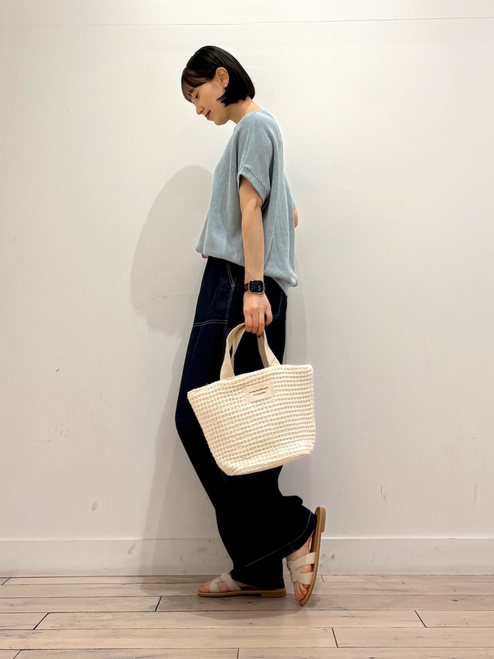 ブルー系のTシャツ/カットソー、ブルー系のデニムパンツ、ホワイト系のトートバッグを着用したレディースの春コーディネートの4枚目の写真