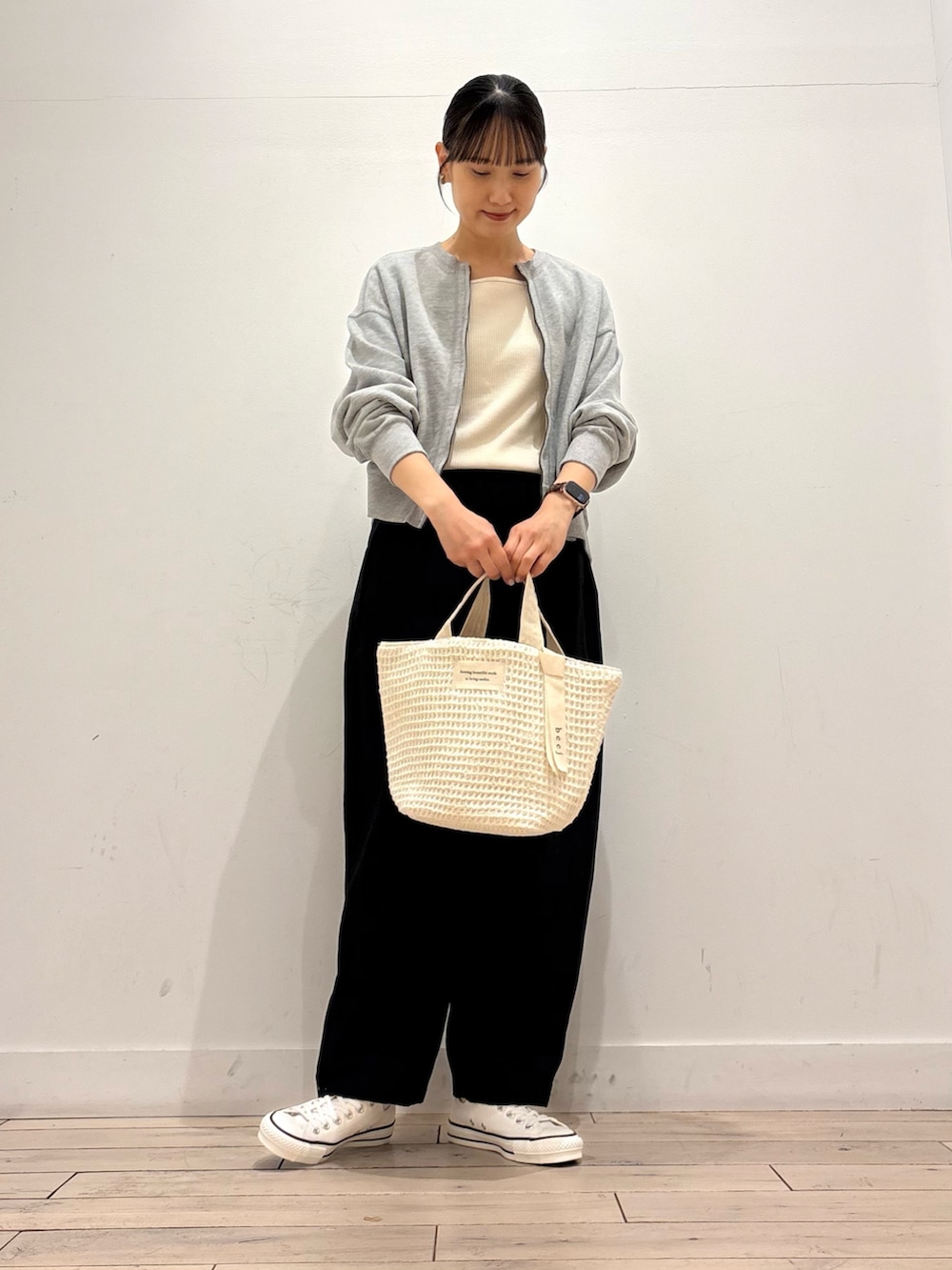 ホワイト系のタンクトップ、グレー系のカーディガン/ボレロ、ホワイト系のトートバッグを着用したレディースの春コーディネートの2枚目の写真