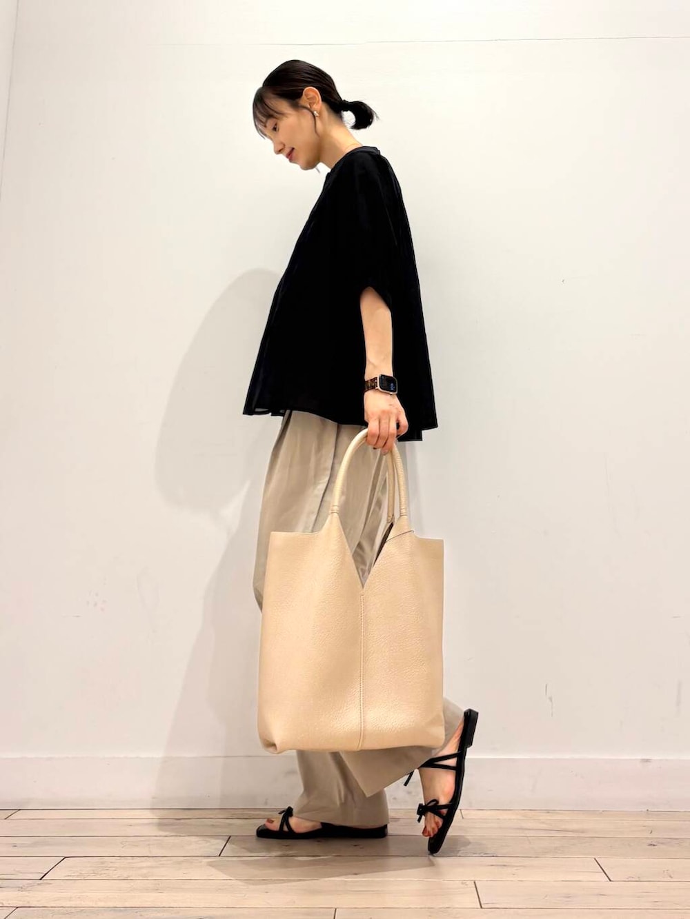 ベージュ系のその他パンツ、ゴールド系のトートバッグ、ブラック系のシャツ/ブラウスを着用したレディースの夏コーディネートの3枚目の写真