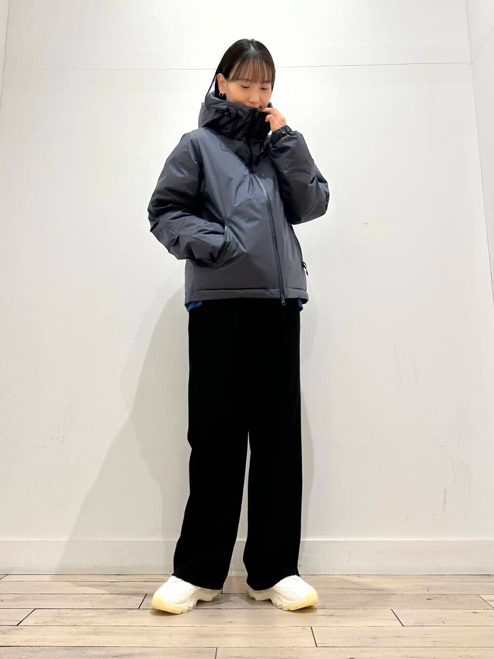 ホワイト系のスニーカー、グリーン系のニット/セーター、シルバー系のトートバッグを着用したレディースの冬コーディネートの3枚目の写真