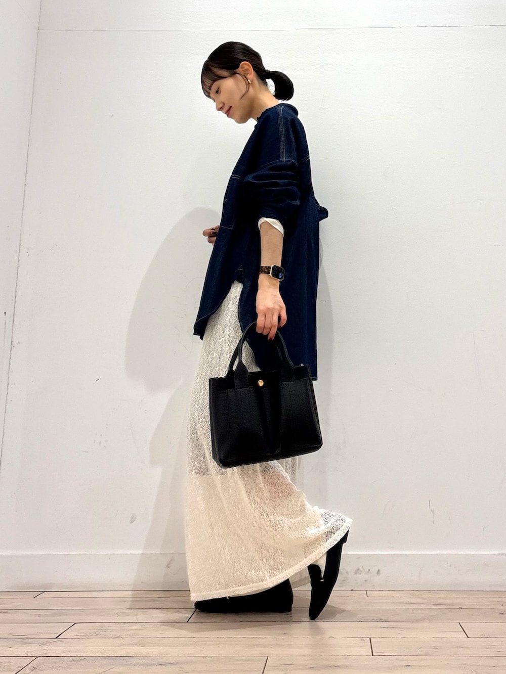 ホワイト系のTシャツ/カットソー、ホワイト系のスカート、ブラック系のトートバッグを着用したレディースの冬コーディネートの2枚目の写真