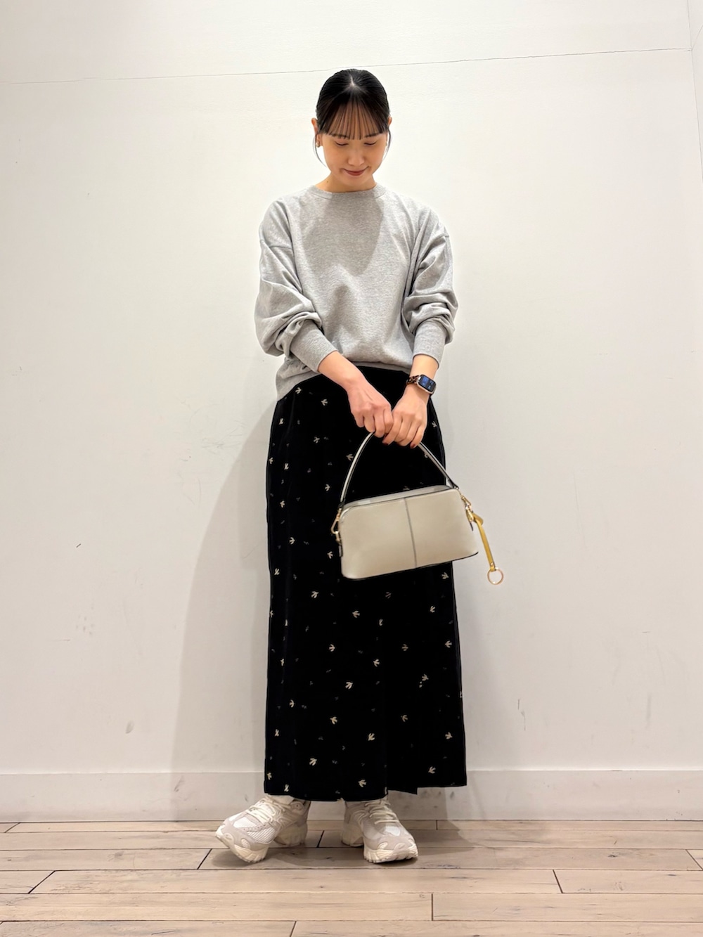 グレー系のTシャツ/カットソー、ブラック系のスカート、ホワイト系のショルダーバッグを着用したレディースの春コーディネートの3枚目の写真