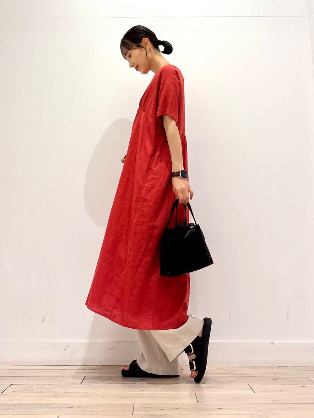 ブラック系のショルダーバッグ、ブラック系のサンダル、レッド系のワンピースを着用したレディースの夏コーディネートの3枚目の写真