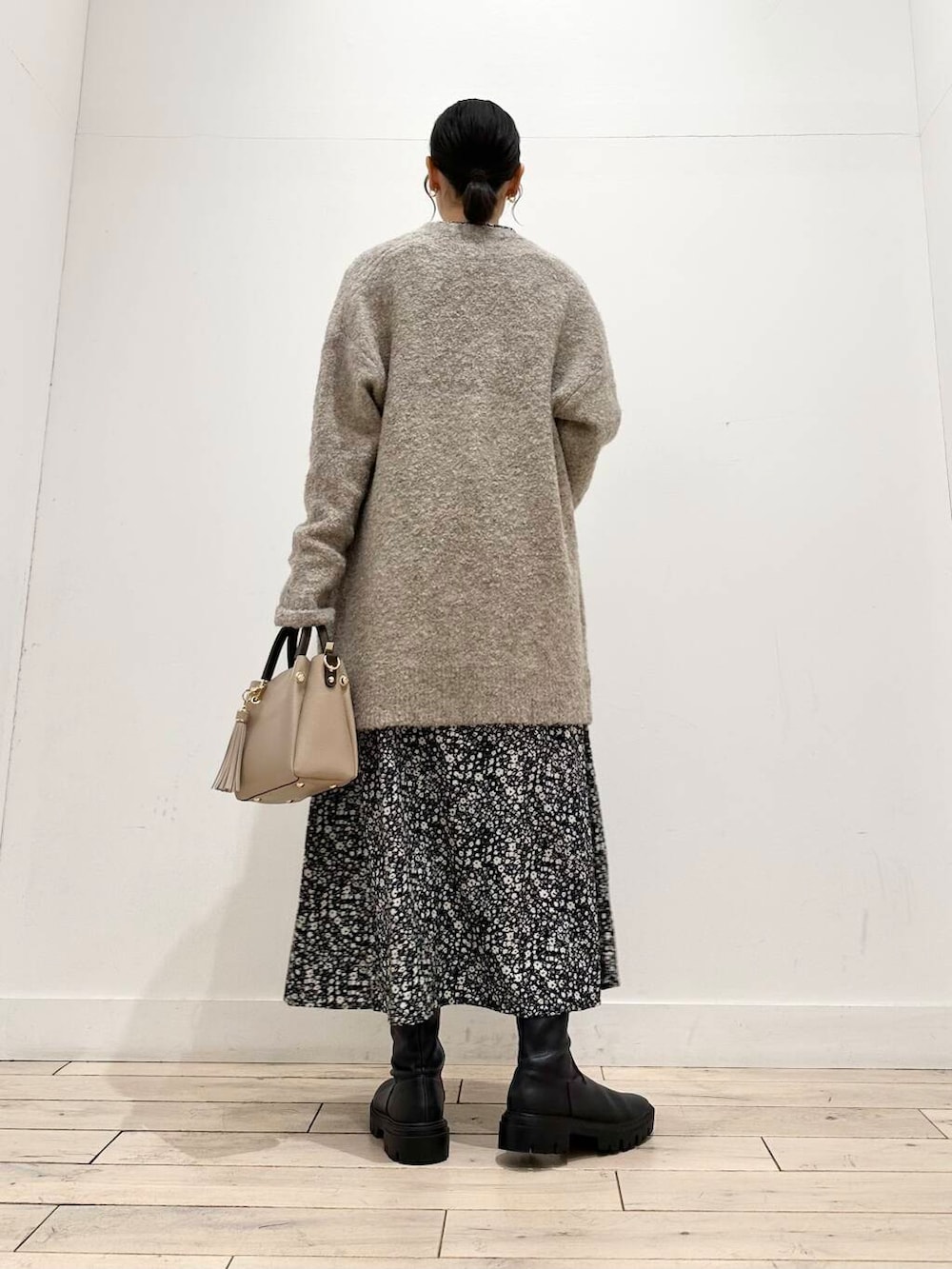 ベージュ系のトートバッグ、ブラック系のブーツ、ベージュ系のカーディガン/ボレロを着用したレディースの冬コーディネートの4枚目の写真