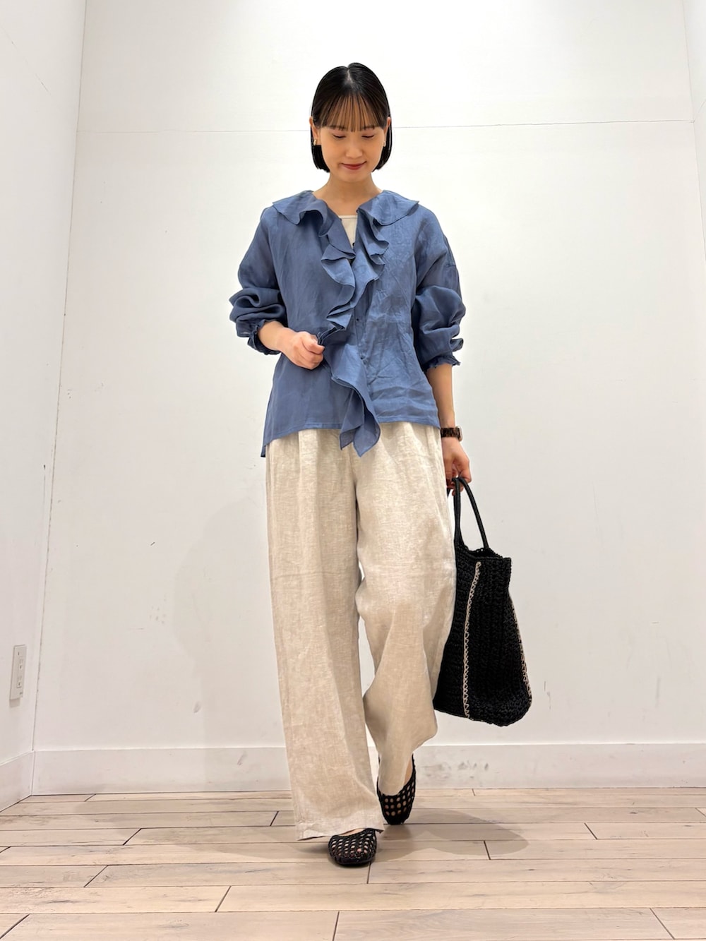 ブルー系のシャツ/ブラウス、ベージュ系のその他パンツ、ブラック系のトートバッグを着用したレディースの春コーディネートの2枚目の写真