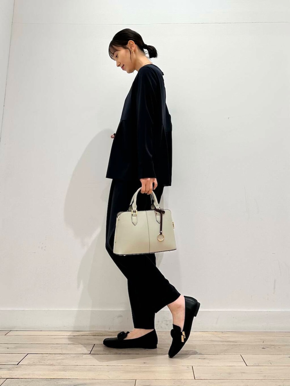ブラック系のドレスシューズ、グレー系のハンドバッグ、ブルー系のセットアップを着用したレディースの冬コーディネートの5枚目の写真