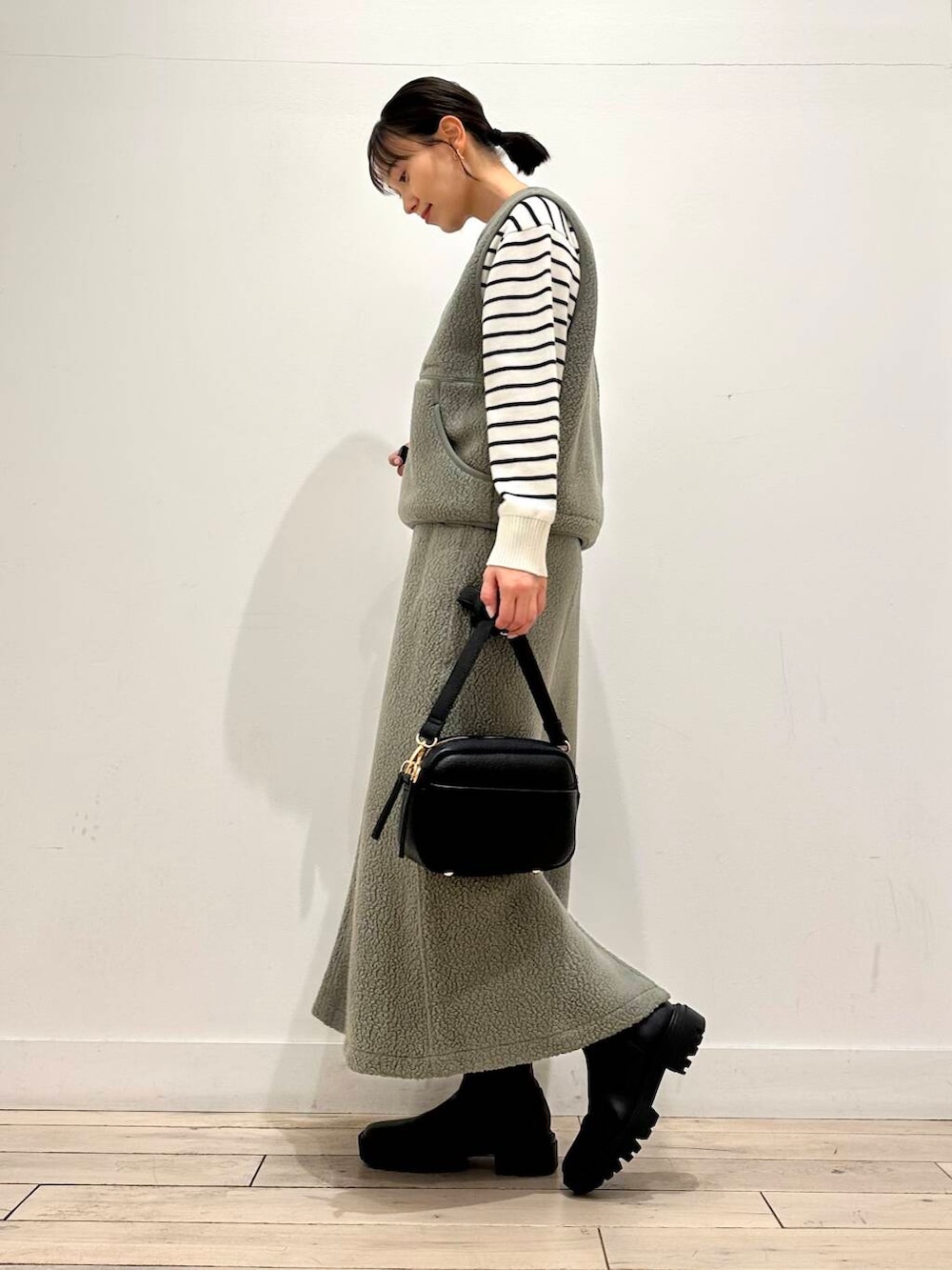 ブラック系のニット/セーター、ブラック系のショルダーバッグ、ブラック系のブーツを着用したレディースの冬コーディネートの3枚目の写真