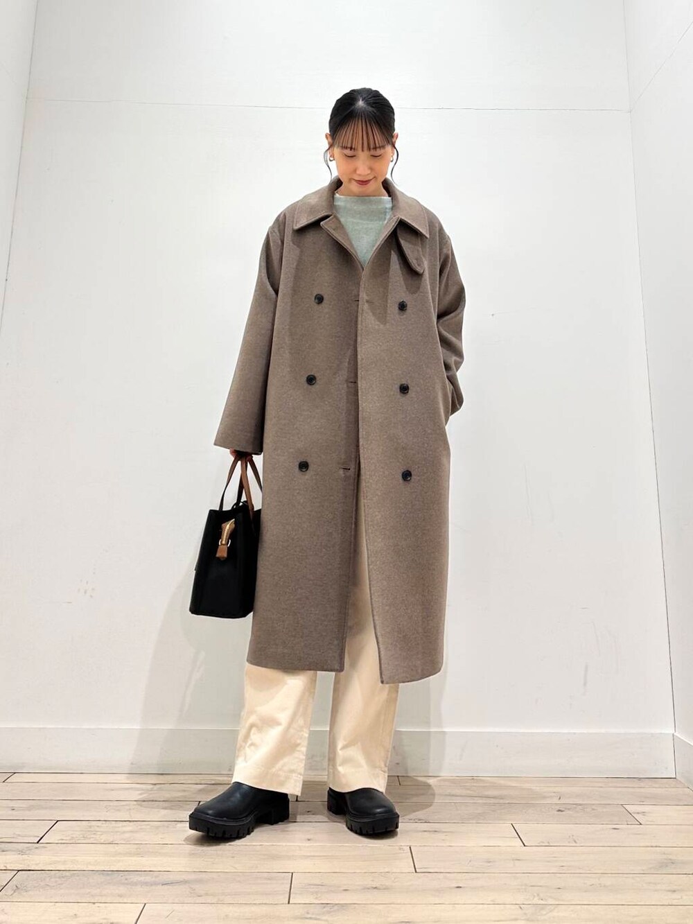 ブラック系のトートバッグ、グリーン系のニット/セーター、ブラック系のブーツを着用したレディースの冬コーディネートの5枚目の写真