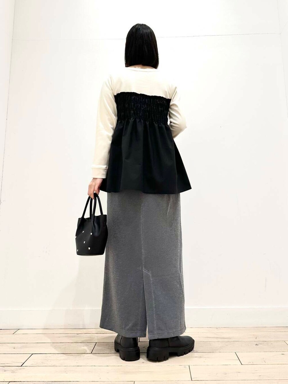 グレー系のその他アウター、ブラック系のブーツ、グレー系のスカートを着用したレディースの冬コーディネートの3枚目の写真