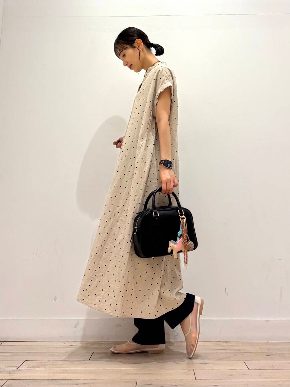 ブルー系のデニムパンツ、ホワイト系のバレエシューズ、ブラック系のボストンバッグを着用したレディースの夏コーディネートの3枚目の写真