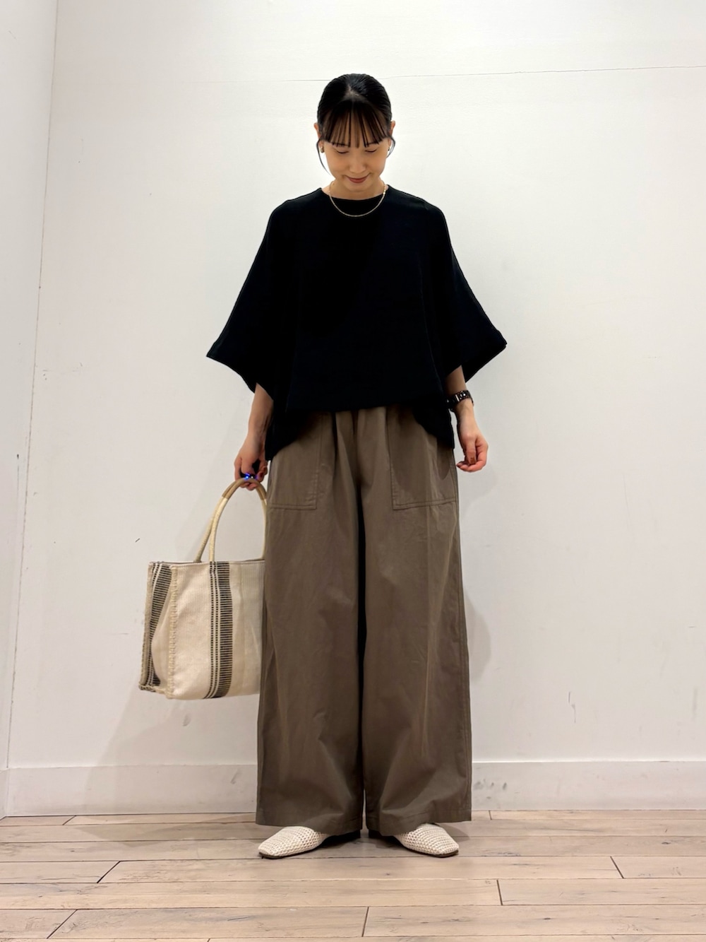 ブラック系のシャツ/ブラウス、グリーン系のその他パンツ、ホワイト系のトートバッグを着用したレディースの夏コーディネートの2枚目の写真