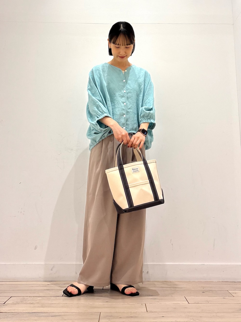 グリーン系のシャツ/ブラウス、ベージュ系のその他パンツ、グレー系のトートバッグを着用したレディースの春コーディネートの2枚目の写真