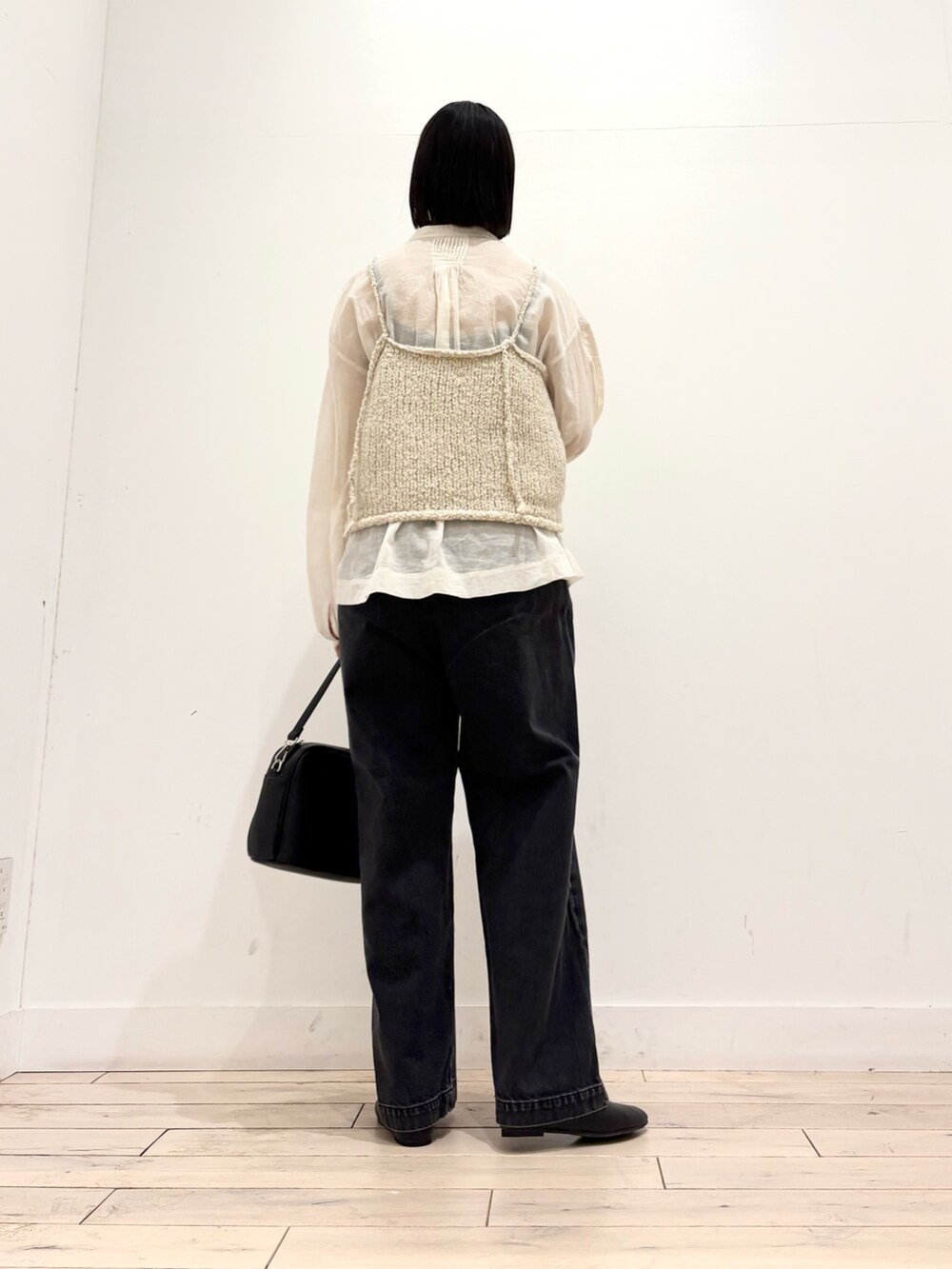 パープル系のニット/セーター、ホワイト系のシャツ/ブラウス、ブラック系のショルダーバッグを着用したレディースの秋コーディネートの5枚目の写真