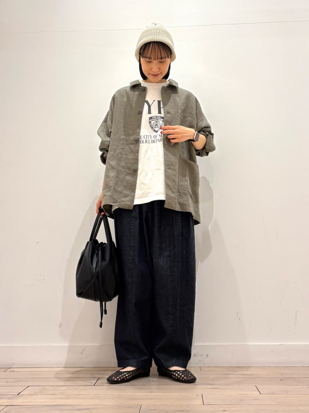 ブラック系のショルダーバッグ、ブラック系のサンダル、ブルー系のデニムパンツを着用したレディースの春コーディネートの2枚目の写真