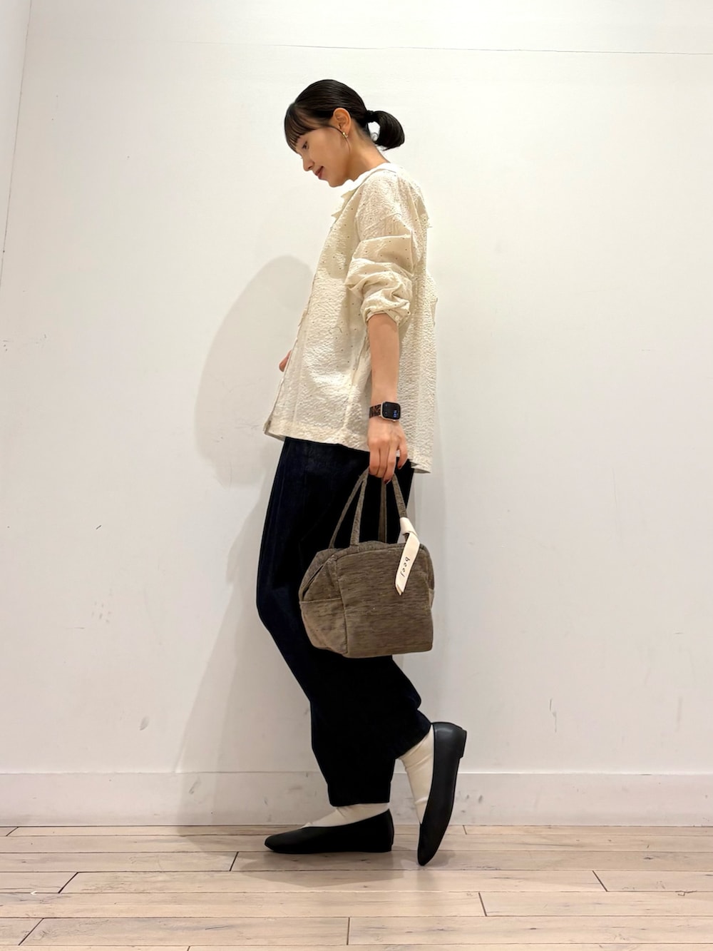ホワイト系のシャツ/ブラウス、ブルー系のデニムパンツ、グリーン系のハンドバッグを着用したレディースの秋コーディネートの3枚目の写真