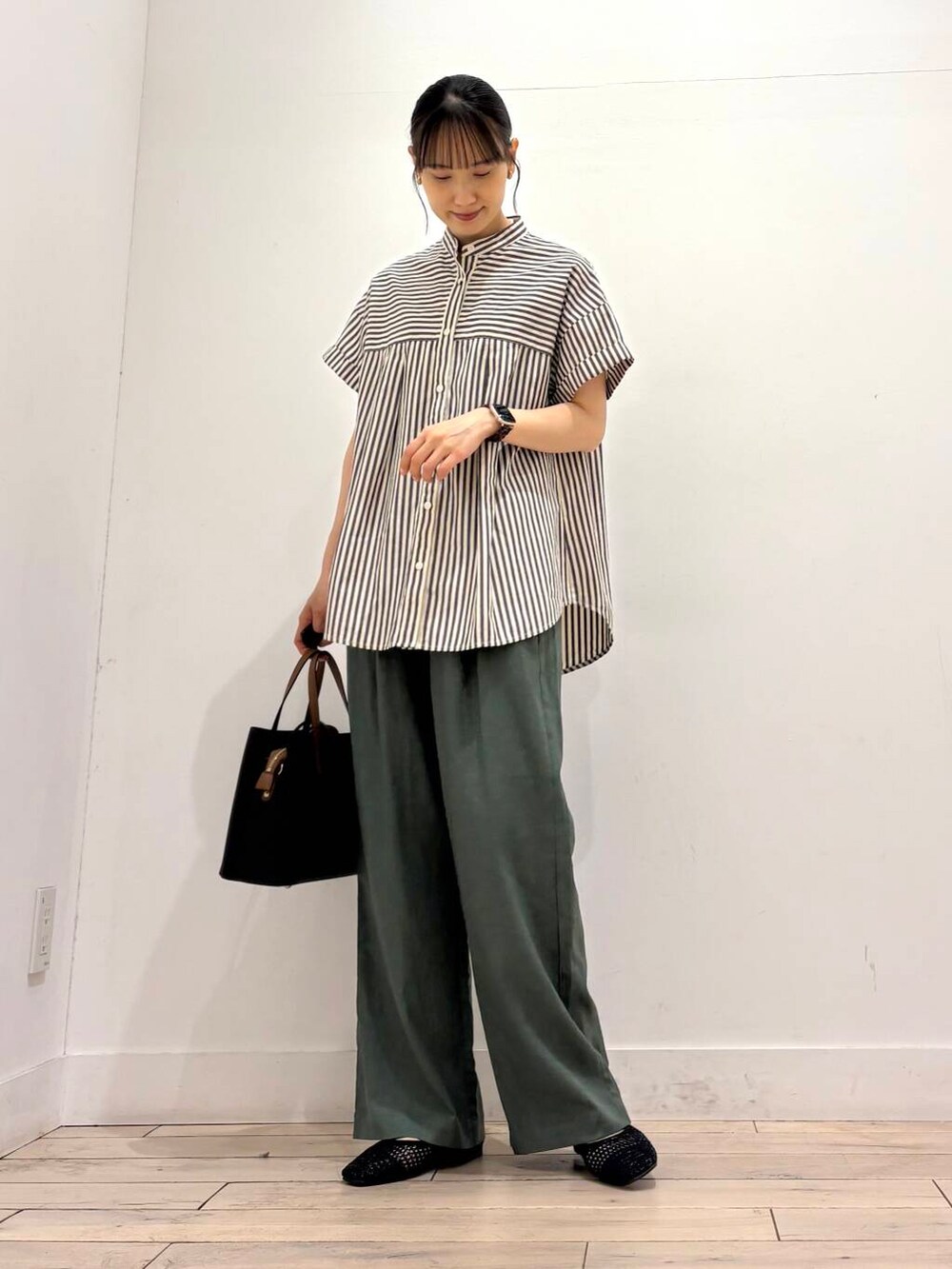 ブラック系のトートバッグ、ブラック系のバレエシューズ、ブラック系のシャツ/ブラウスを着用したレディースの夏コーディネートの2枚目の写真