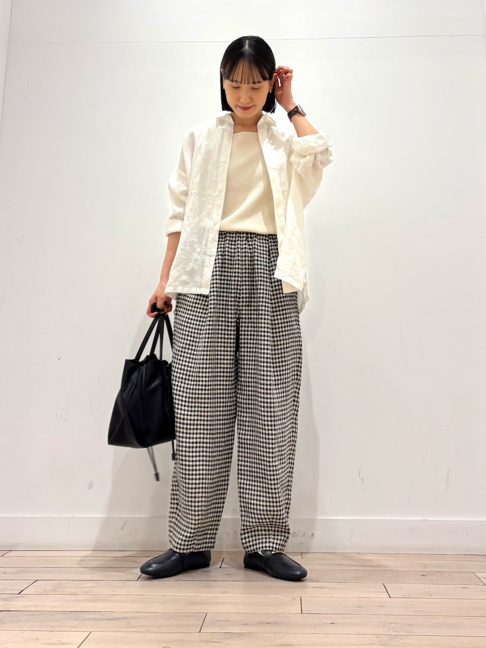 ホワイト系のタンクトップ、ホワイト系のシャツ/ブラウス、ブラック系のショルダーバッグを着用したレディースの春コーディネートの3枚目の写真