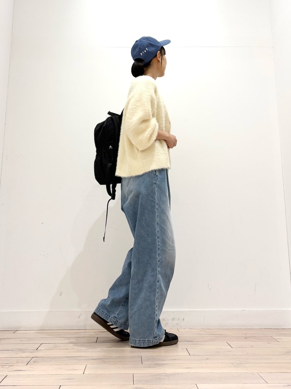 ホワイト系のカーディガン/ボレロ、ブルー系のデニムパンツ、ブラック系のスニーカーを着用したレディースの秋コーディネートの4枚目の写真