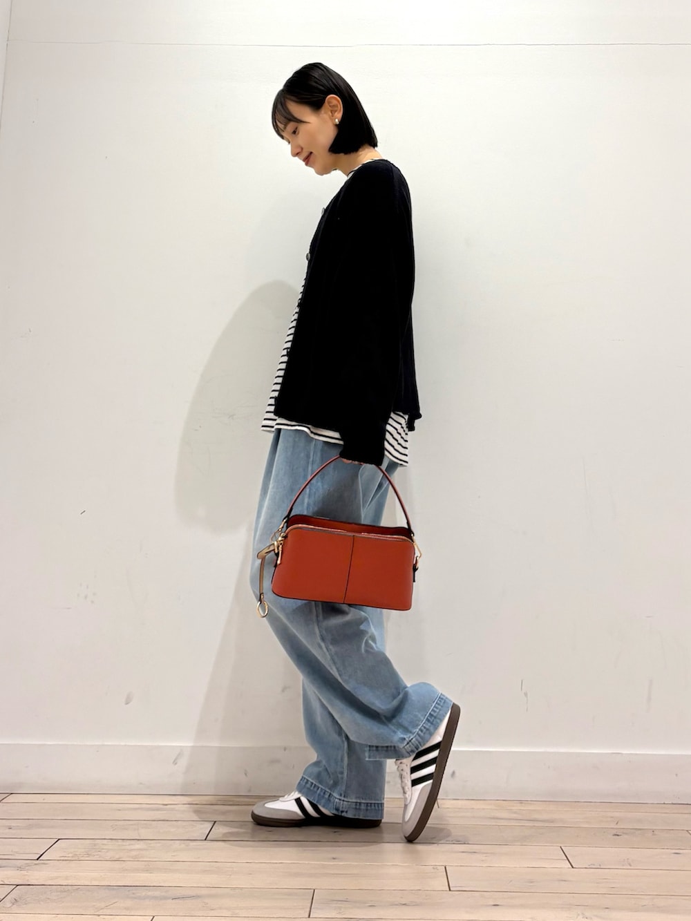 ブラック系のカーディガン/ボレロ、ブルー系のデニムパンツ、ホワイト系のスニーカーを着用したレディースの冬コーディネートの3枚目の写真