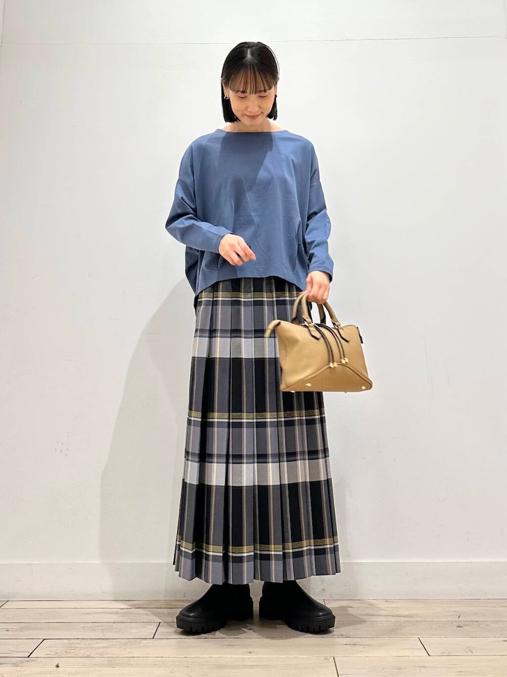 ブルー系のTシャツ/カットソー、ブラウン系のボストンバッグ、ブラック系のブーツを着用したレディースの秋コーディネートの2枚目の写真