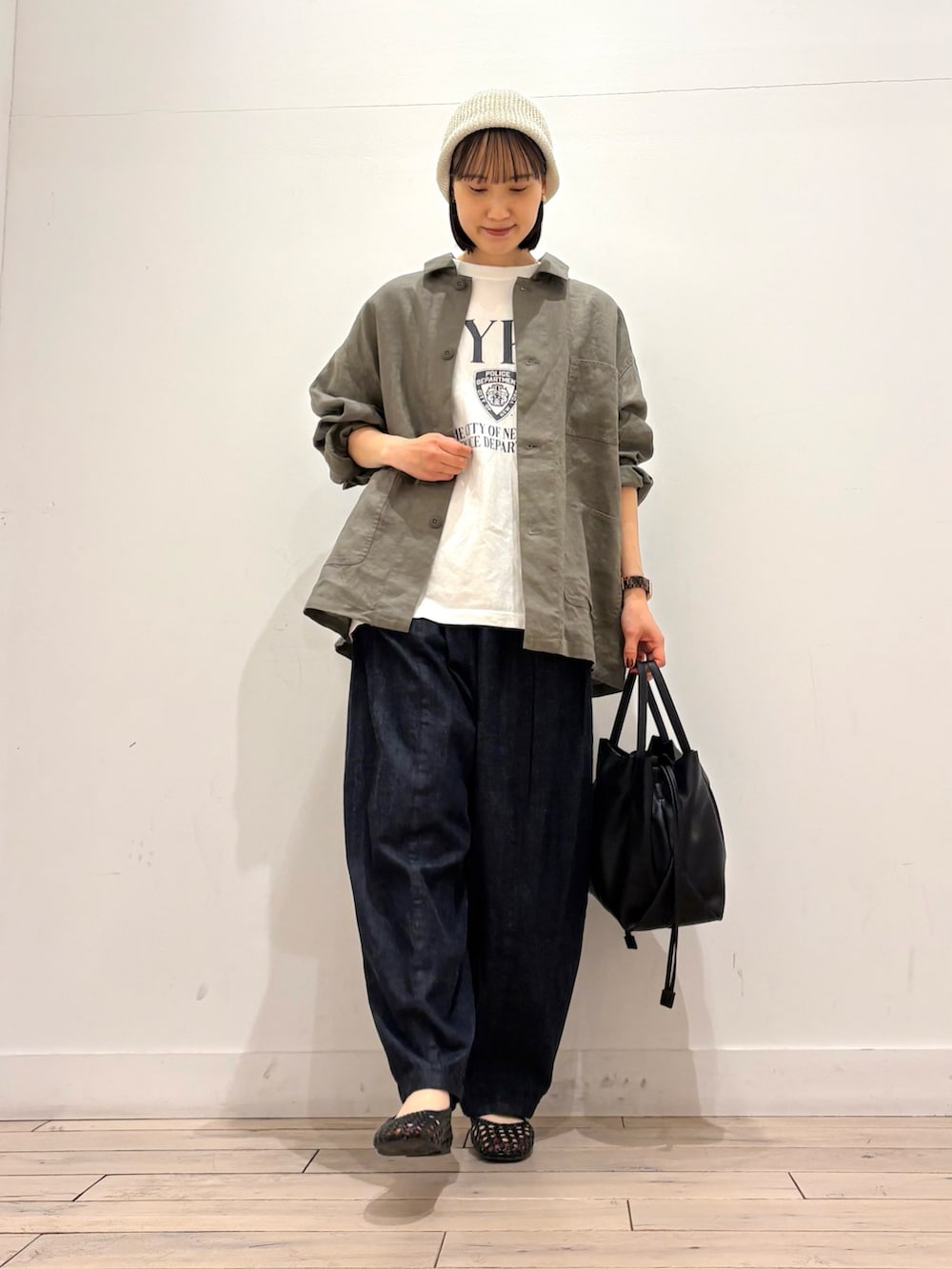 ブラック系のショルダーバッグ、ブラック系のサンダル、ブルー系のデニムパンツを着用したレディースの春コーディネートの3枚目の写真