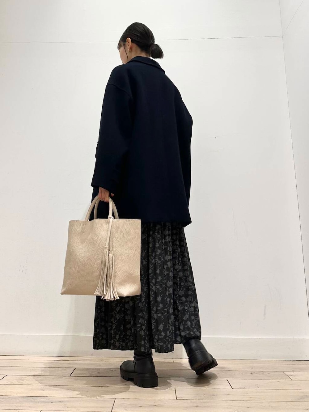 ホワイト系のトートバッグ、ブルー系のその他アウター、ブラック系のブーツを着用したレディースの冬コーディネートの3枚目の写真