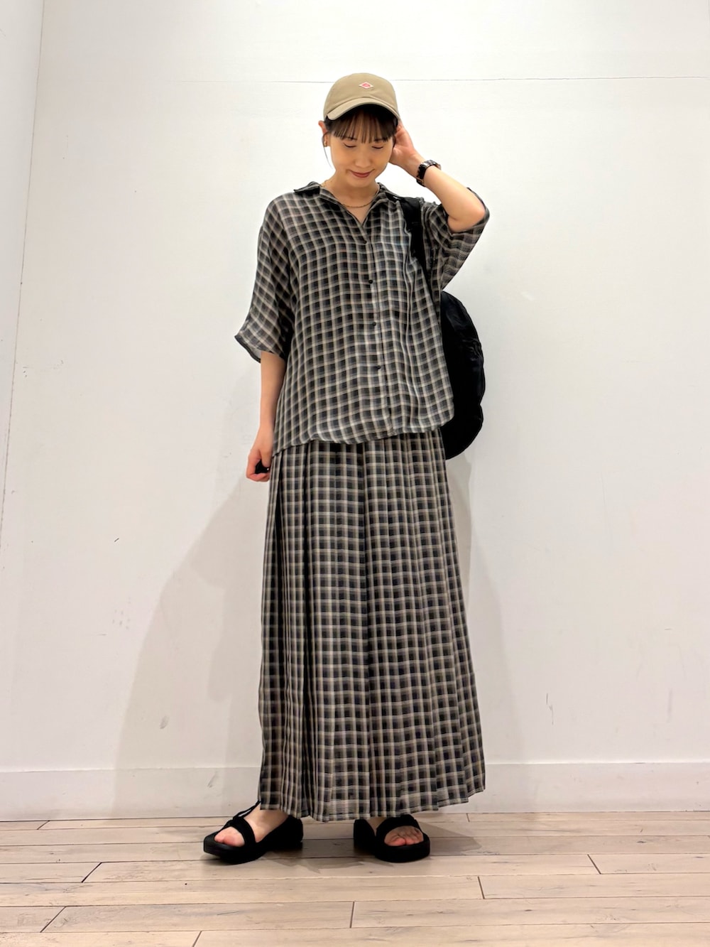 ベージュ系のシャツ/ブラウス、ベージュ系のスカート、ブラック系のサンダルを着用したレディースの夏コーディネートの3枚目の写真