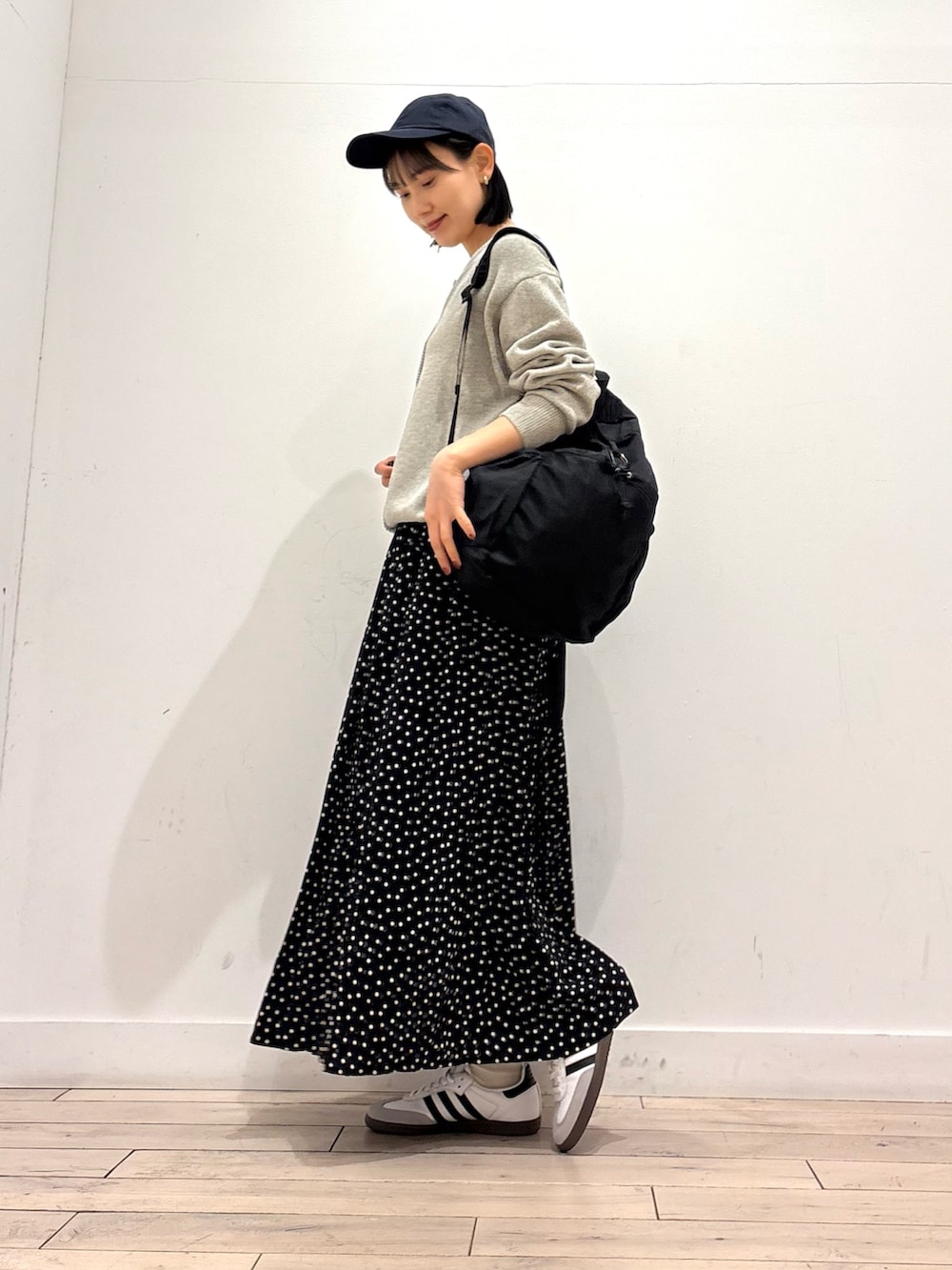 グレー系のニット/セーター、ブラック系のスカート、ブラック系のバックパック/リュックを着用したレディースの冬コーディネートの3枚目の写真