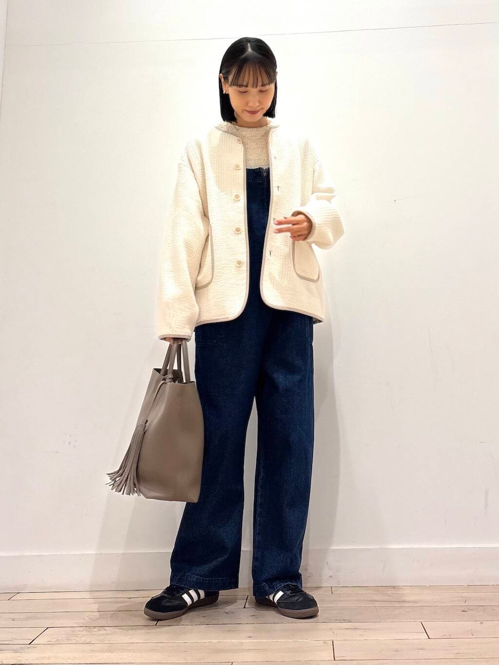 ブルー系のサロペット/オーバーオール、グレー系のトートバッグ、ホワイト系のノーカラージャケットを着用したレディースの春コーディネートの4枚目の写真