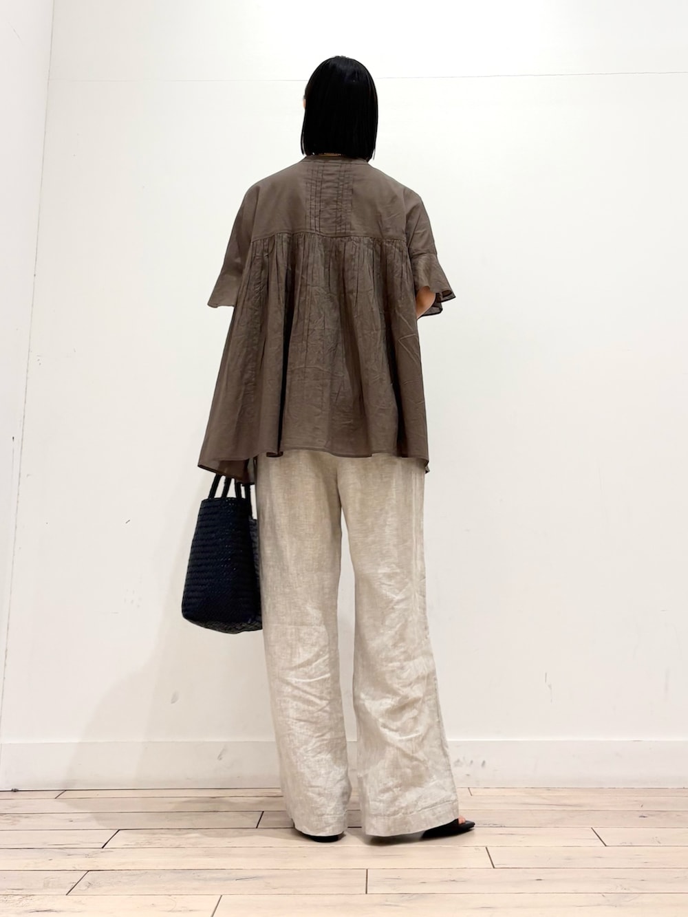 ブルー系のトートバッグ、ベージュ系のその他パンツ、ブラック系のサンダルを着用したレディースの春コーディネートの5枚目の写真