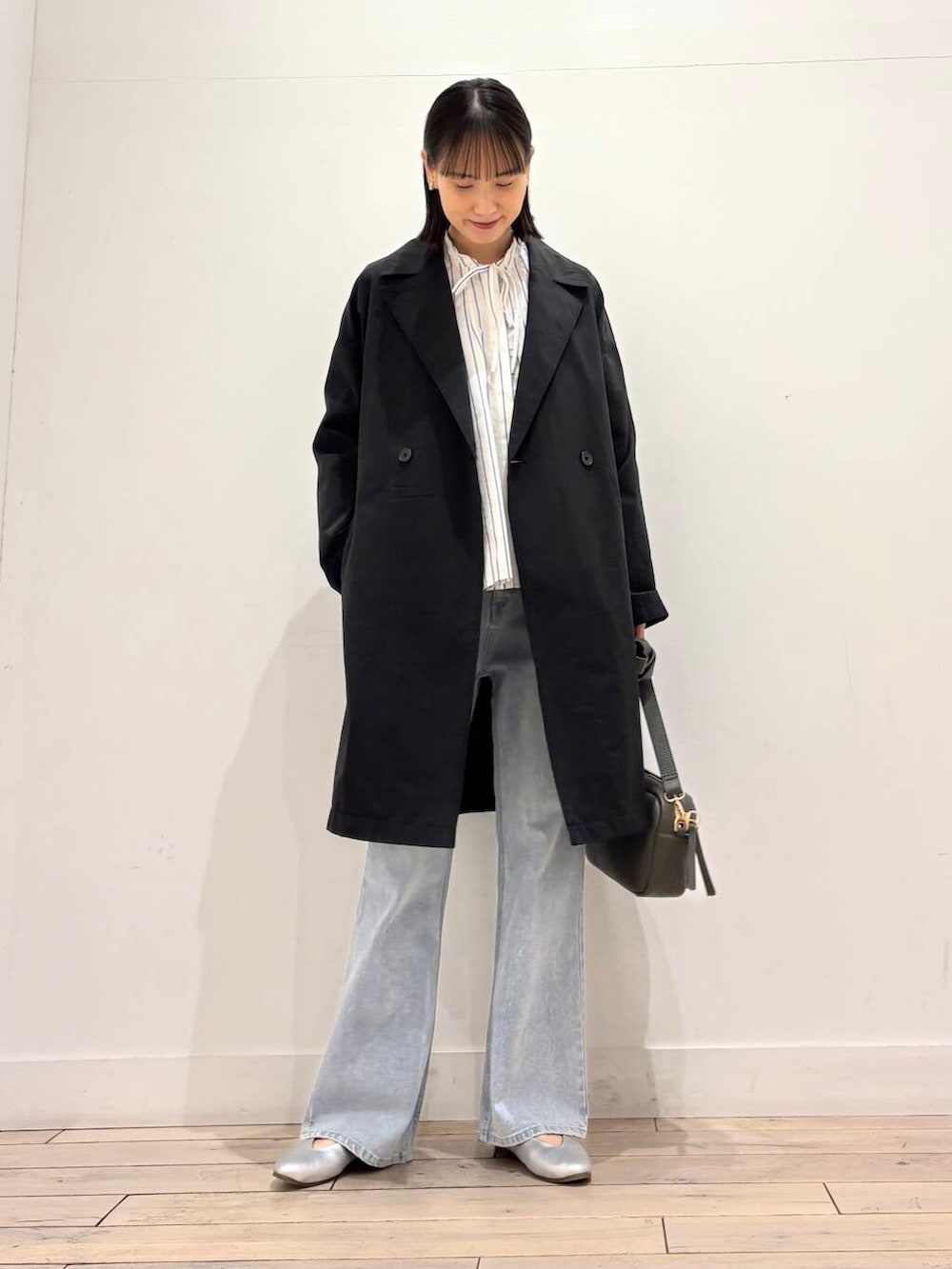 グリーン系のショルダーバッグ、シルバー系のパンプス、ブルー系のデニムパンツを着用したレディースの春コーディネートの6枚目の写真