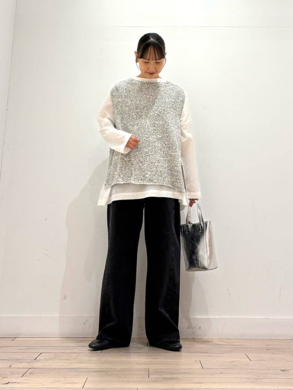 ホワイト系のシャツ/ブラウス、ブラック系のデニムパンツ、シルバー系のトートバッグを着用したレディースの秋コーディネートの3枚目の写真