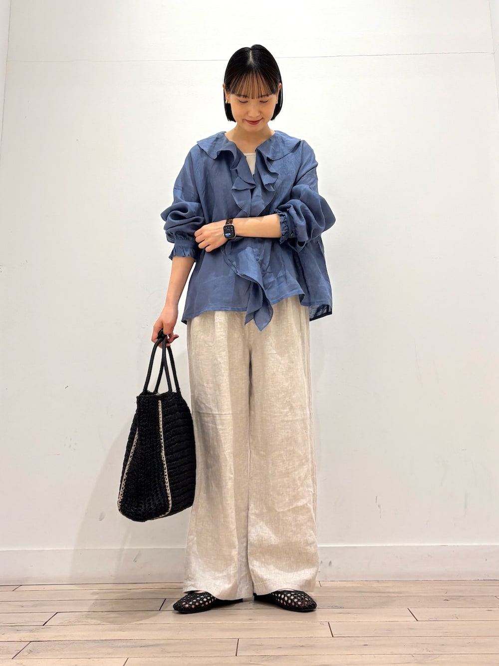 ブルー系のシャツ/ブラウス、ベージュ系のその他パンツ、ブラック系のトートバッグを着用したレディースの春コーディネートの3枚目の写真