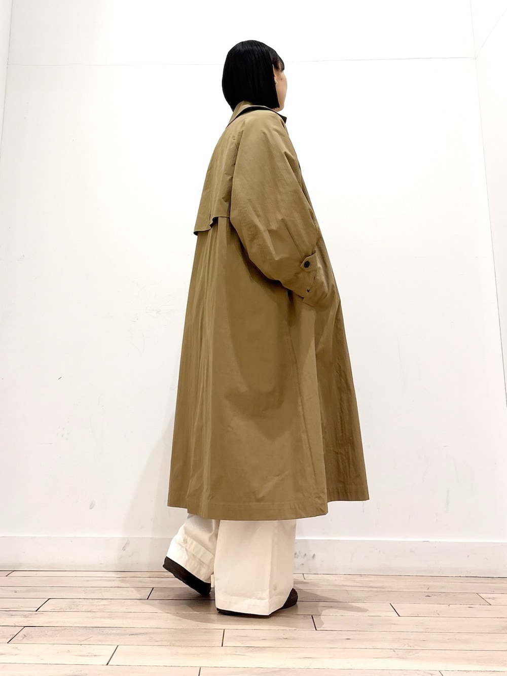 ベージュ系のニット/セーター、ベージュ系のトレンチコート、ブラウン系のトートバッグを着用したレディースの冬コーディネートの2枚目の写真