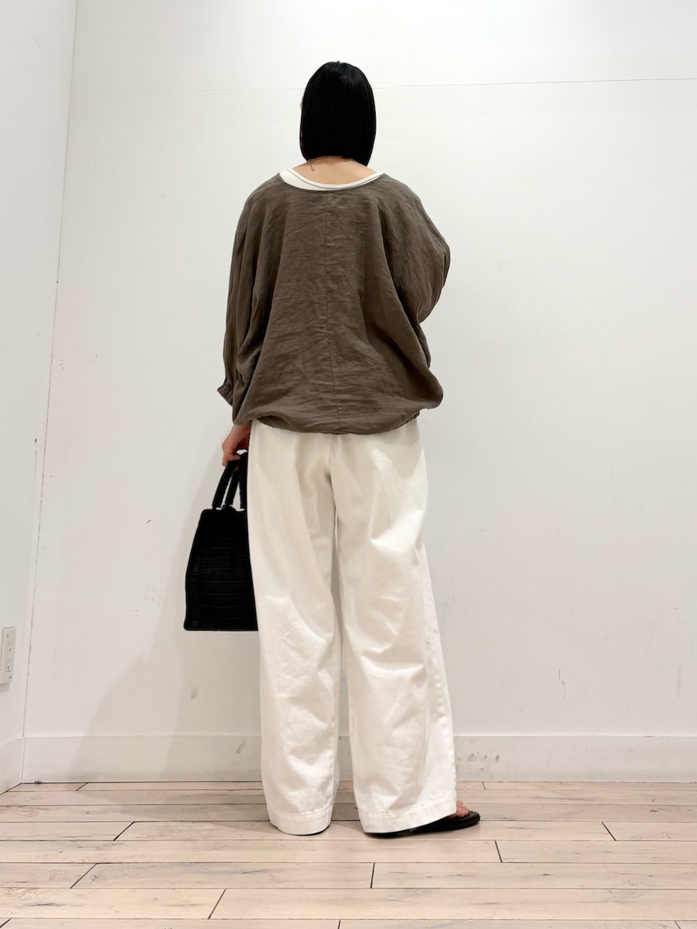 ホワイト系のその他パンツ、ブラック系のハンドバッグ、ブラック系のサンダルを着用したレディースの夏コーディネートの5枚目の写真