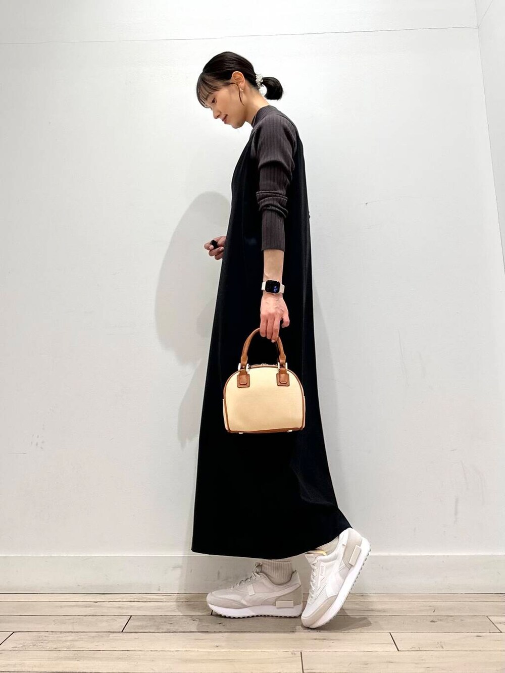 ブラウン系のニット/セーター、ホワイト系のダウンジャケット/コート、イエロー系のボストンバッグを着用したレディースの冬コーディネートの4枚目の写真